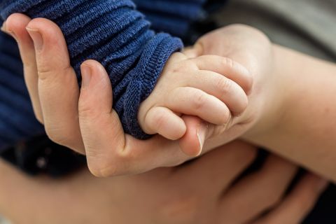 Kind hält die Hand eines Erwachsenen – Symbol für Unterstützung, Vertrauen und Begleitung für Familien von Kindern mit Behinderungen durch die Beratungsstelle für vorschulische und schulische Integration.