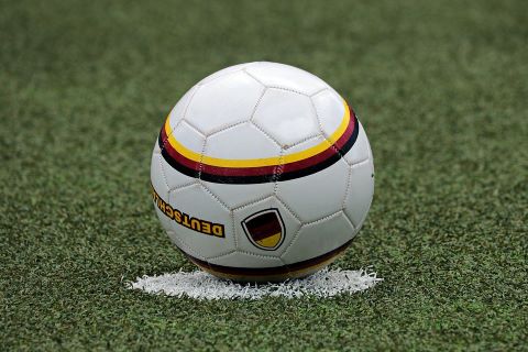 Fußball im Mittelpunkt des Mittelkreises auf einem Fußballfeld.