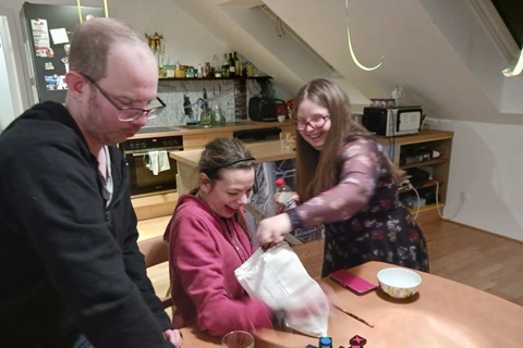 Zwei Personen stehen im Gemeinschaftsgarten der Wohngemeinschaft vor einem Hochbeet.