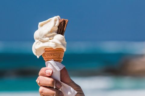 Hand hält eine Waffeltüte mit Eiscreme.