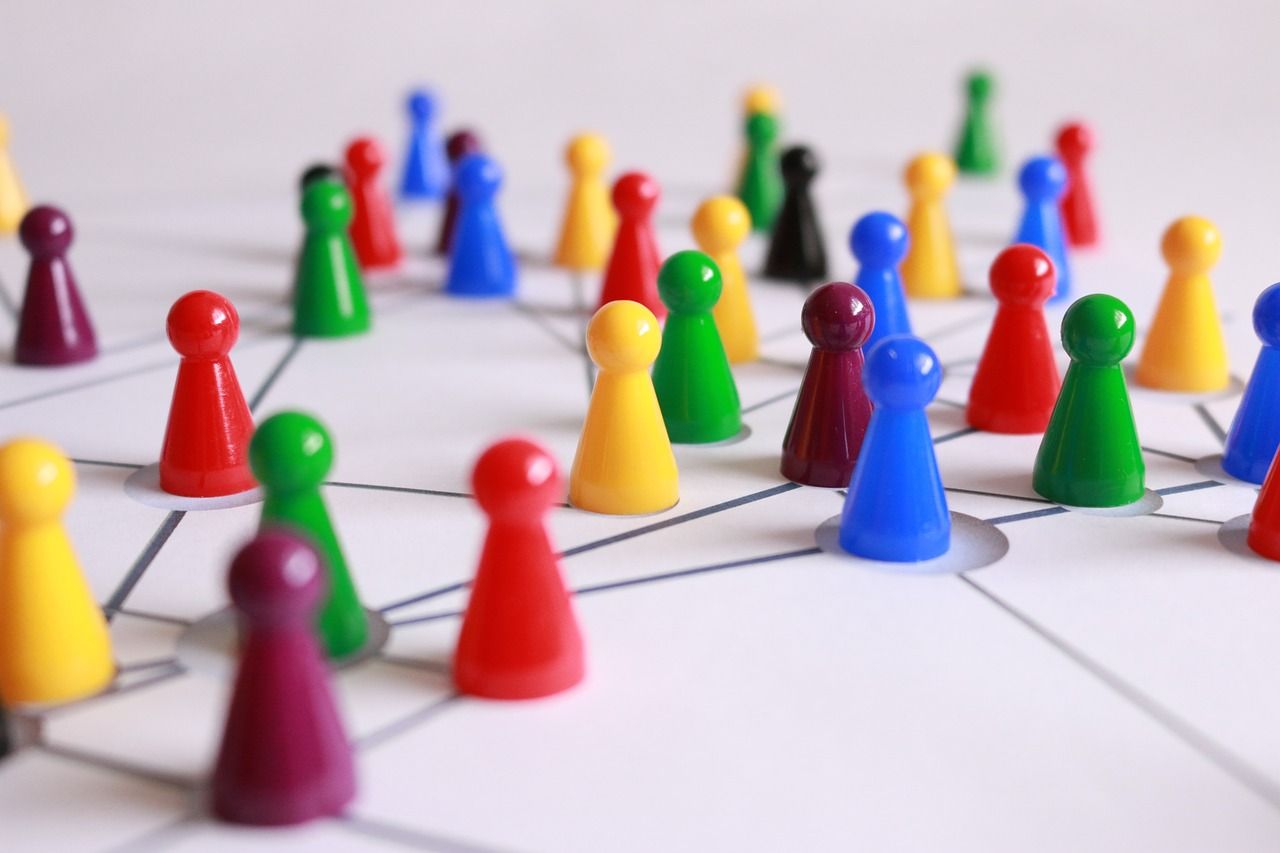 Bunte Spielfiguren die auf Linien stehen und ein Team darstellen.