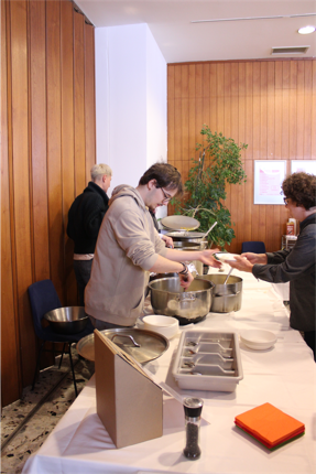 Auf dem Foto gibt ein Helfer des Catering-Teams das Mittagessen aus.